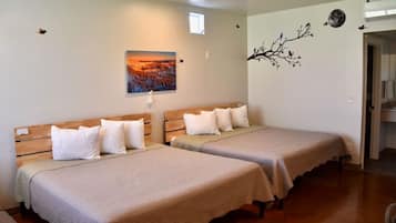 A hotel room with two single beds, a nightstand, a wall-mounted painting, and a decorative tree branch.