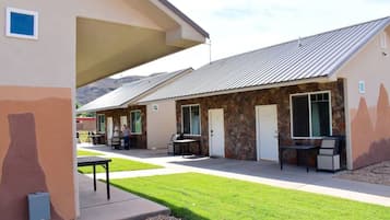 A building with a stone facade, multiple doors, and outdoor seating areas.