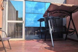 A patio with a sliding glass door, a folding table, and a chair. - Pu'er Guopei Hotel (Pu'er)