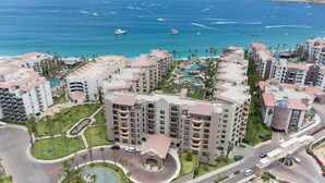 Een resort met meerdere gebouwen, een centraal gelegen zwembad en uitzicht op de oceaan.