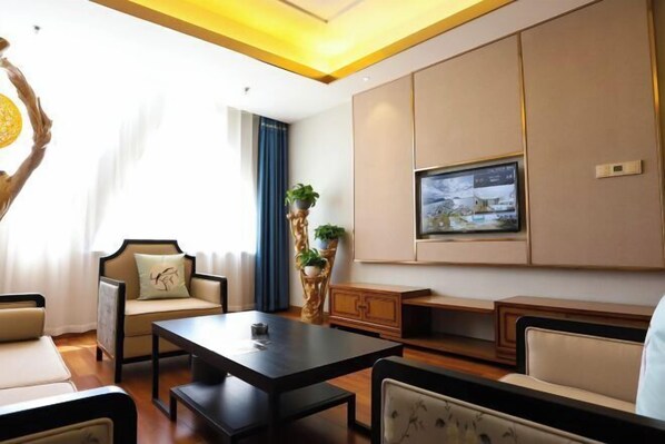 A modern living room with a sofa, a coffee table, and a TV mounted on the wall.