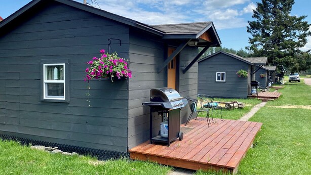 Un hilera de cabañas con una parrilla y zona de estar al aire libre.