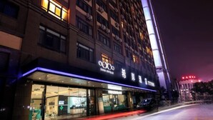 Un hotel con fachada moderna, amplias ventanas de vidrio y un cartel llamativo.