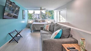 A modern living room with a grey sofa, a coffee table, and a TV mounted on the wall. - Canal-Front Condo: Walk to Downtown Ft Lauderdale! (Fort Lauderdale)