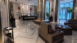 Eine moderne Lobby mit Empfangstresen, Sitzgelegenheiten und großen Fenstern.