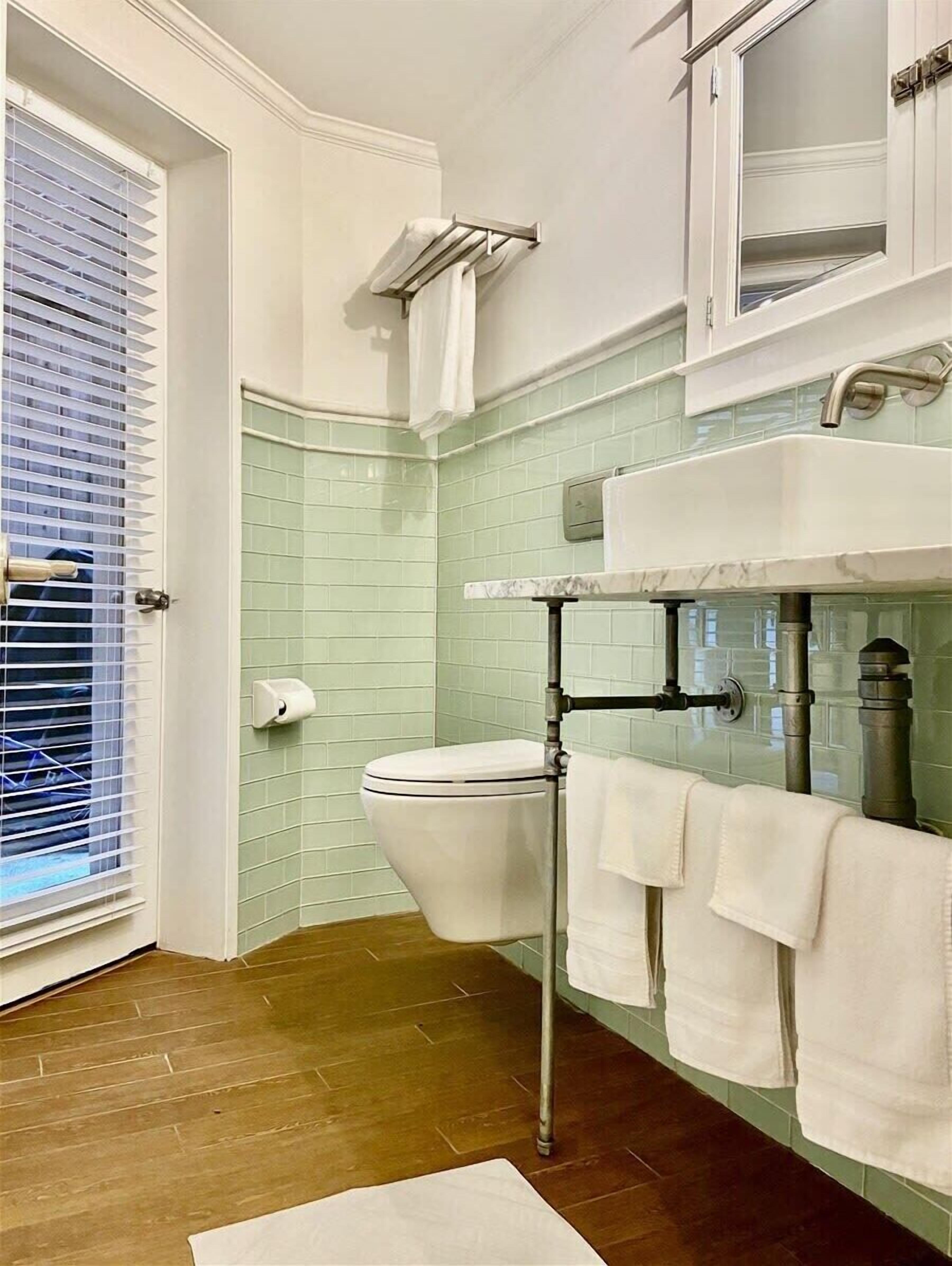 A bathroom with a toilet, sink, and towel rack.