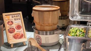 A buffet setup with a wooden steamer and a menu stand.