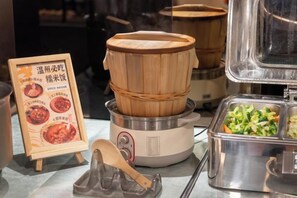 Un buffet avec un cuiseur à vapeur en bois et un présentoir à menus.