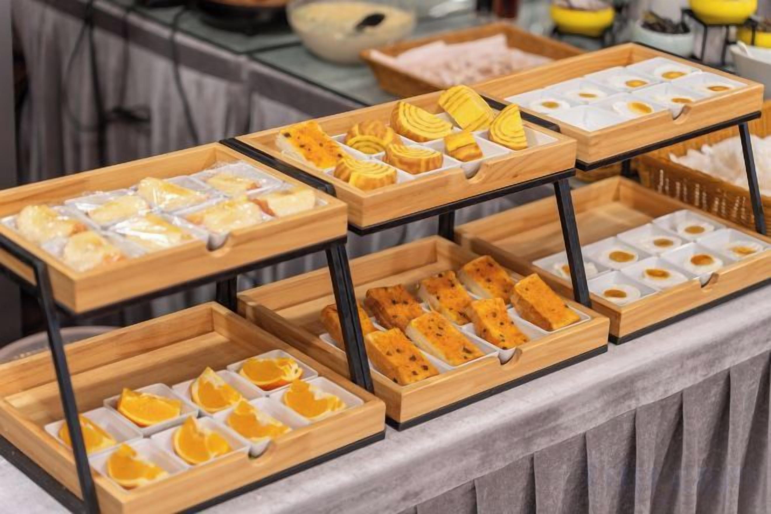 Een buffet met verschillende soorten eten, gerangschikt op houten schalen.