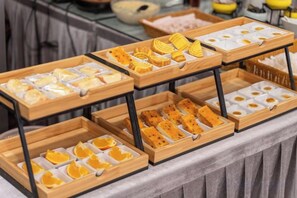 A buffet table with various food items arranged in wooden trays. - Radow Hotel Chain (Wenzhou Railway Station) (Wenzhou)
