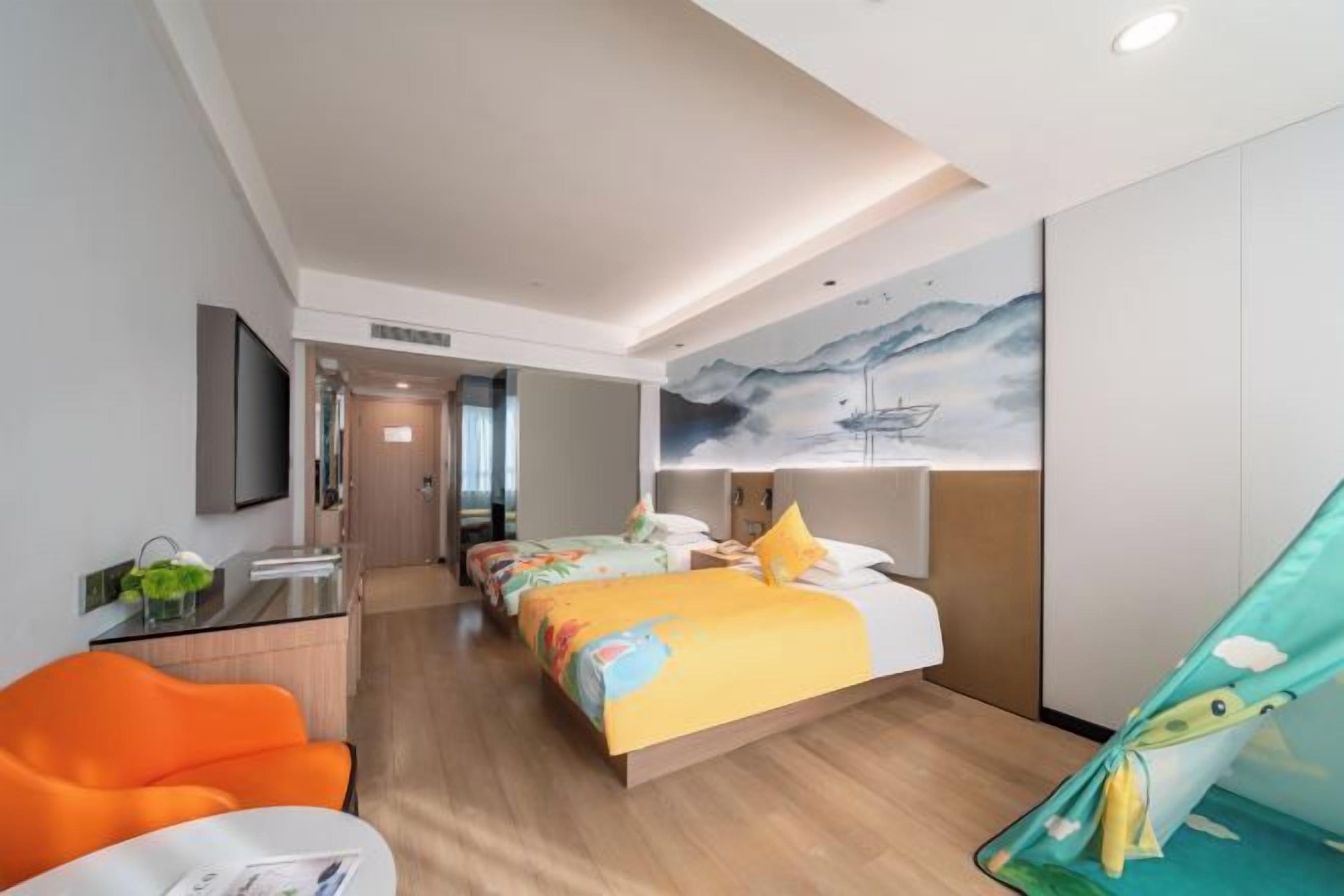 A hotel room with a bed, two bedside tables, a desk, and a chair.