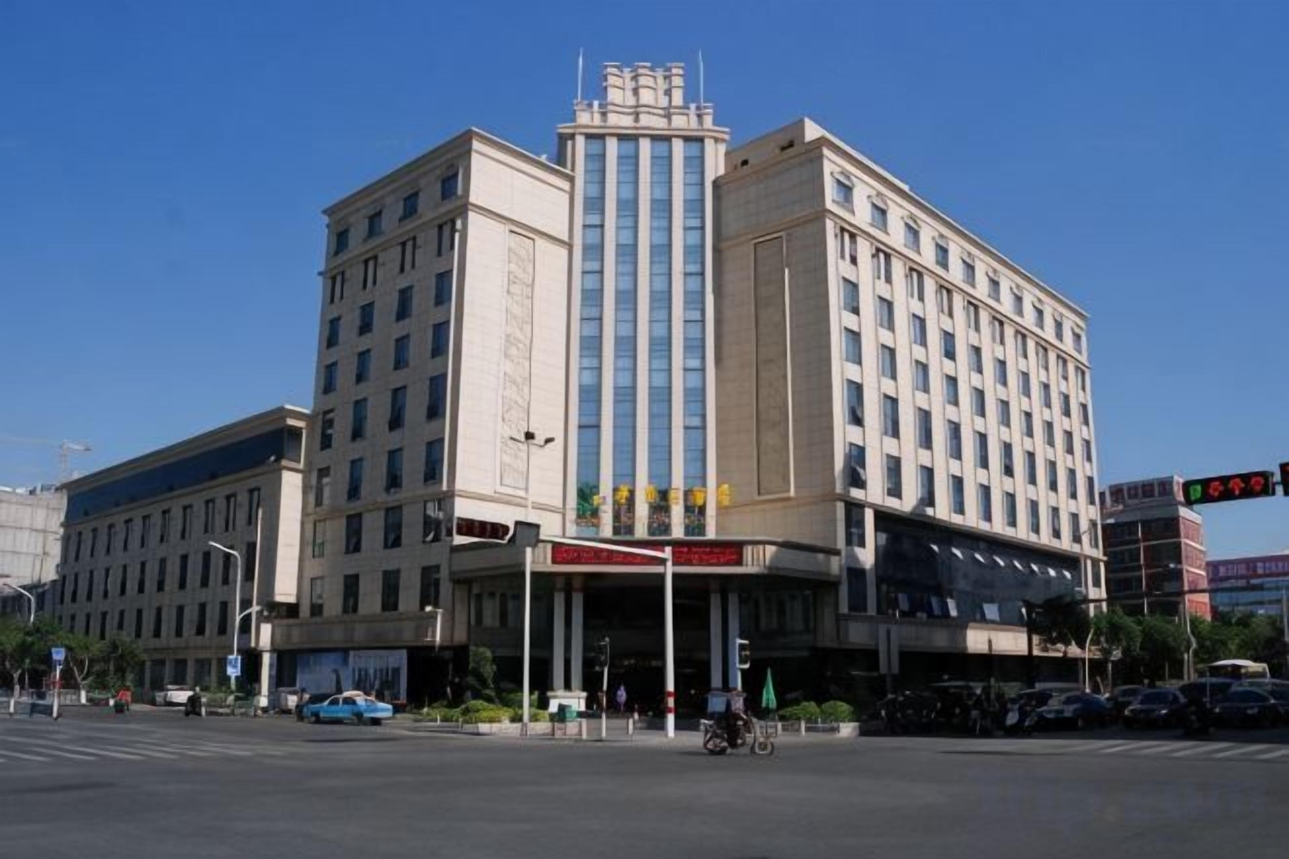 A multi-story hotel with a central entrance and a large sign above the doors.