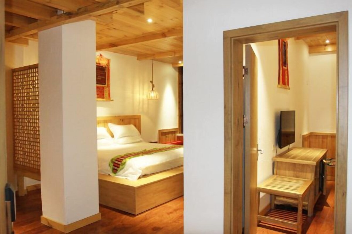 Una cama con estructura de madera, un cabecero, una mesita de noche y una lámpara colgante.