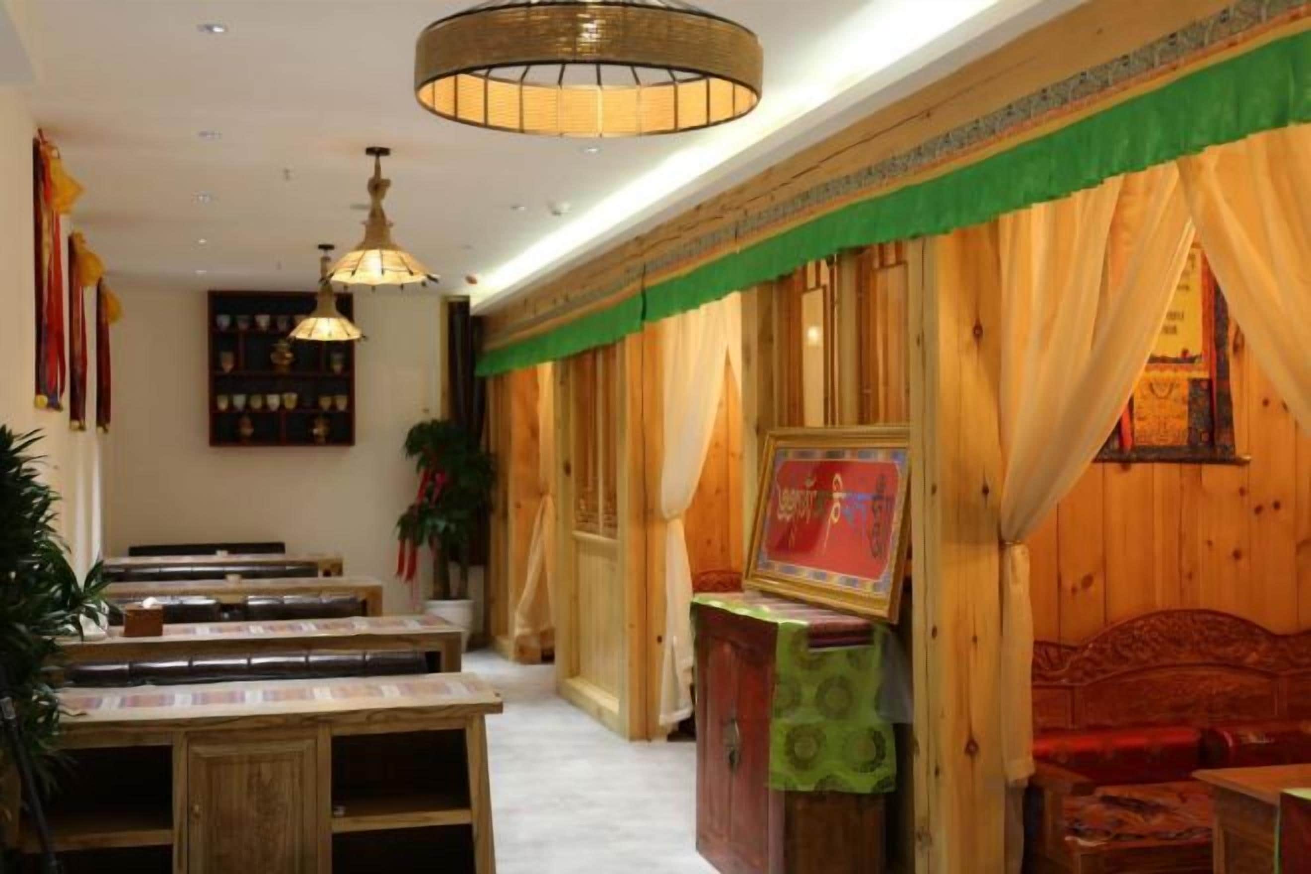A restaurant with wooden tables and chairs, a green awning, and a red sofa.