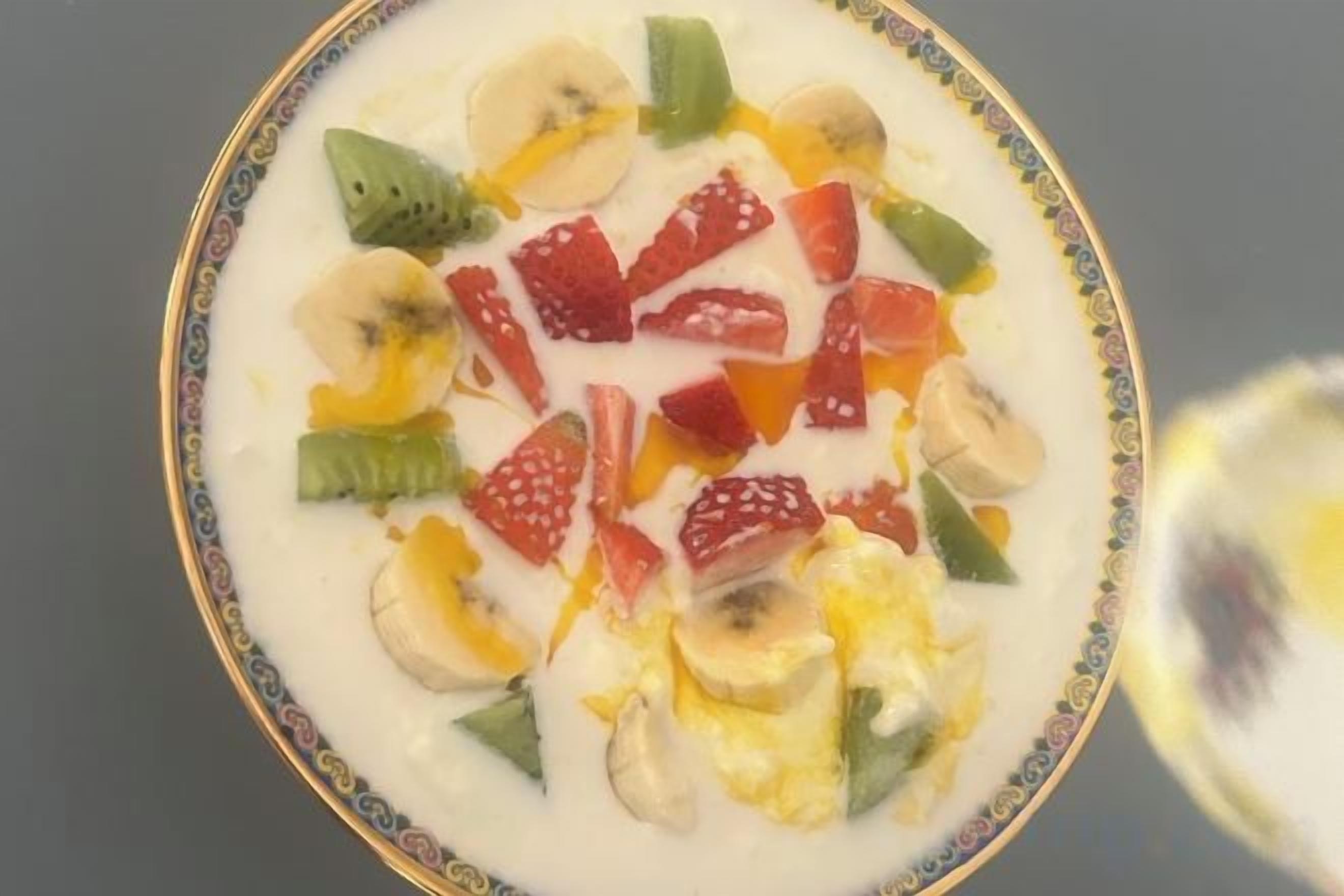 A bowl of yogurt topped with various fruits.