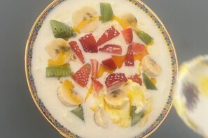 Un bol de yaourt garni de différents fruits.