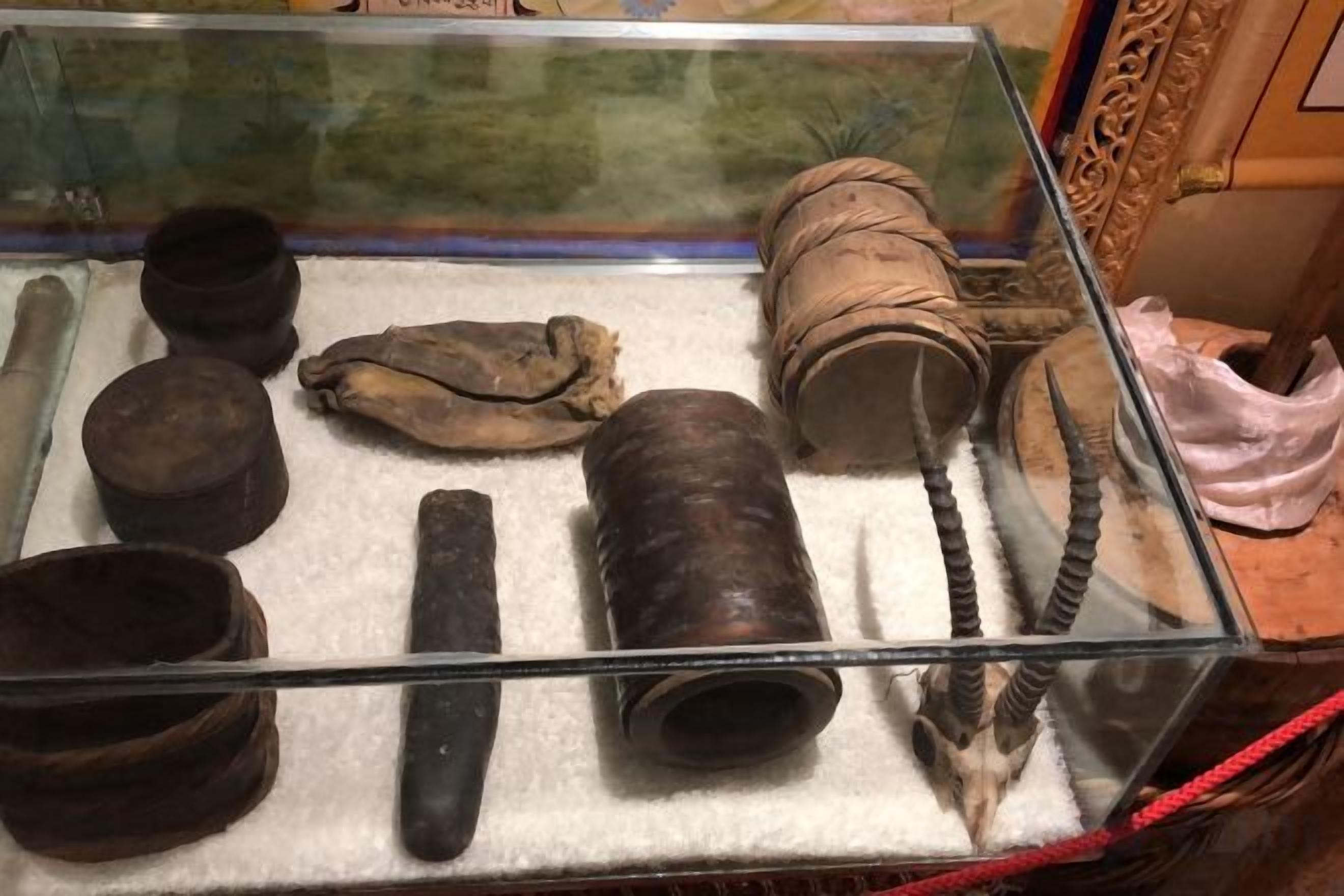 A display case containing various historical artifacts, including pottery, a leather pouch, and a horn.