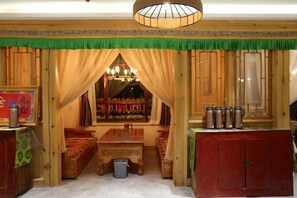 Een kamer met een houten inrichting, een bank, een tafel en een hanglamp.