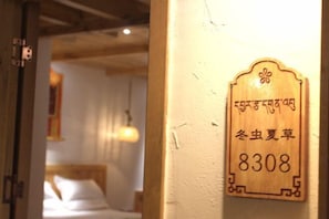 Uma placa de madeira com o número '8308' e algum texto em um alfabeto não latino, provavelmente indicando um número de quarto ou localização dentro de um edifício.