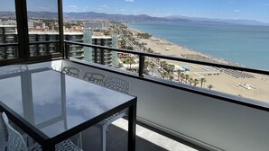 A balcony with a clear view of a beach and ocean.