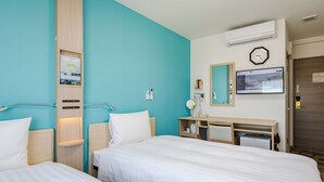 Een hotelkamer met twee bedden, een bureau, een spiegel, een klok en een airconditioning.