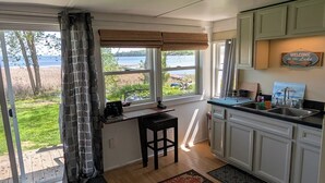 Una cocina con vistas al lago, una zona de comedor con mesa y sillas, y una alfombra con estampado floral.