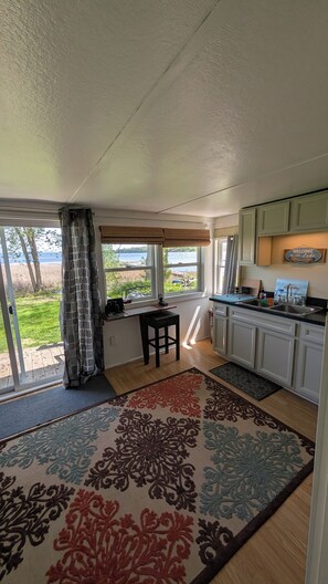 Eine Küche mit Seeblick, ein Essbereich mit Tisch und Stühlen sowie ein Teppich mit Blumenmuster.