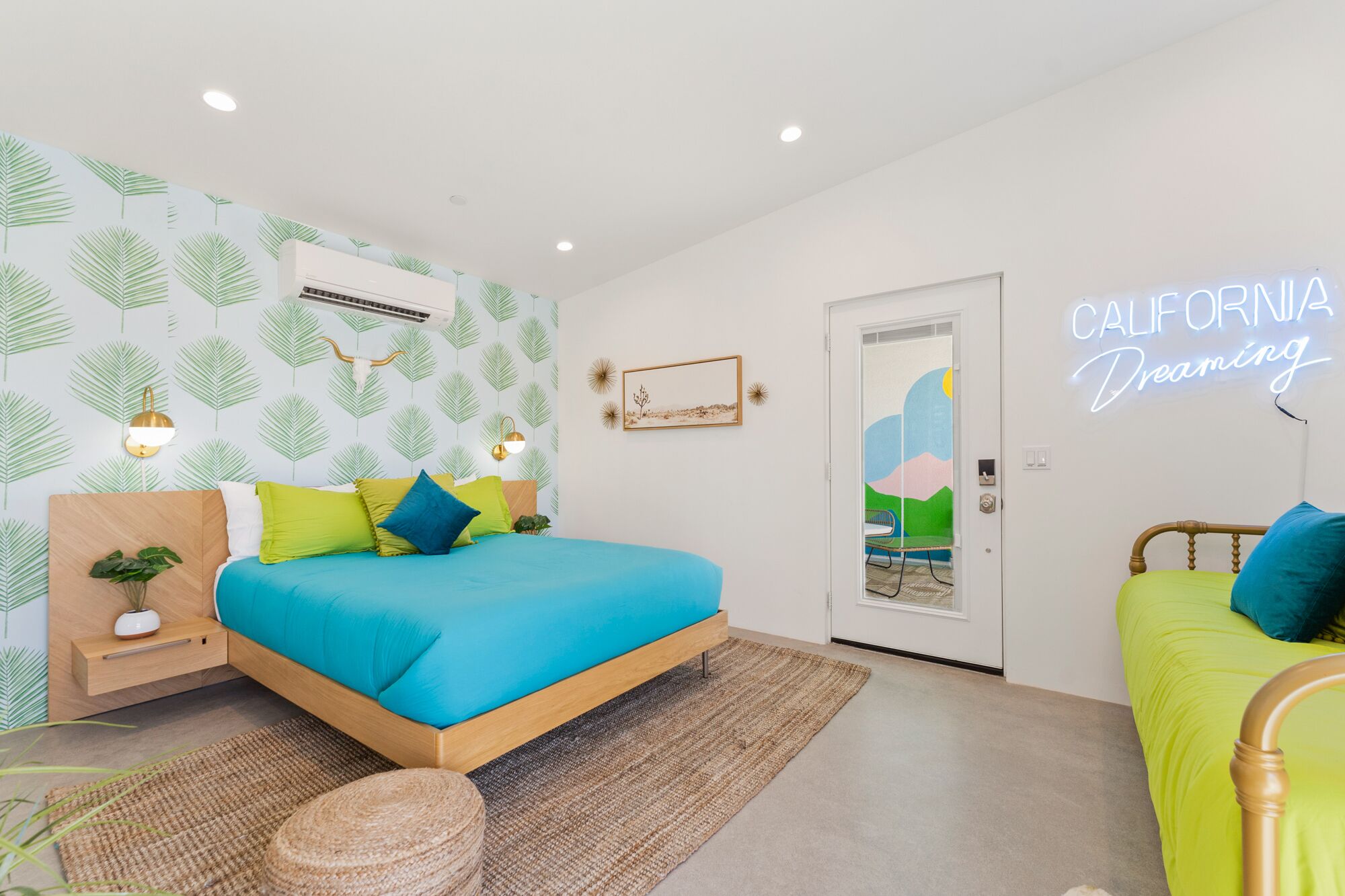 Ein modernes Schlafzimmer mit einem Bett, Nachttischen, einer wandmontierten Klimaanlage und einem Neon-Schild.