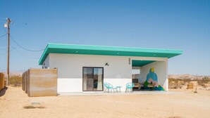 A modern building with a green roof, a large mural, and outdoor seating. - New Listing Discount! Fire Pit~Hammocks (Joshua Tree)