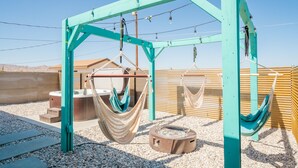 A hammock setup with a fire pit, a wooden deck, and a view of the desert landscape. - New Listing Discount! Fire Pit~Hammocks (Joshua Tree)