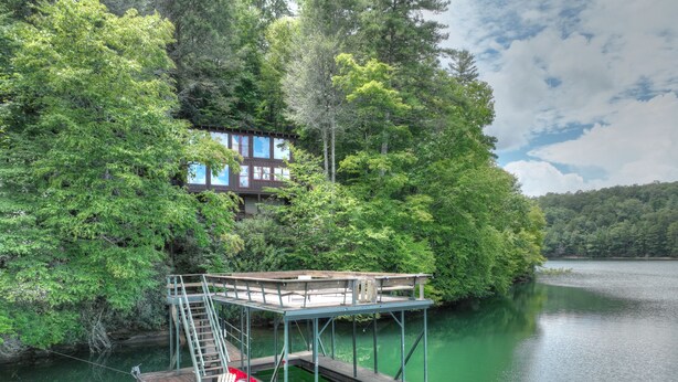 A wooden dock extending into a lake, surrounded by dense green foliage. - The Blue Canoe | Cozy Lakefront Getaway in Blue Ridge | Rustic and Elegant  (Blue Ridge)