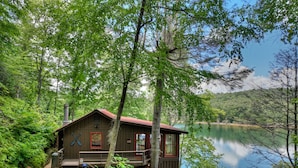 A cabin with a deck and a view of a lake surrounded by trees. - The Blue Canoe | Cozy Lakefront Getaway in Blue Ridge | Rustic and Elegant  (Blue Ridge)