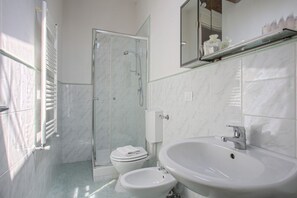 A modern bathroom with a glass shower enclosure, a white sink, and a toilet. - Benvenuto - Sweet Dreams in Florence (Firenze)