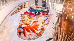 A modern bar area with a colorful floor design, seating arrangements, and a bar counter. - Hilton Kinshasa (Kinshasa)