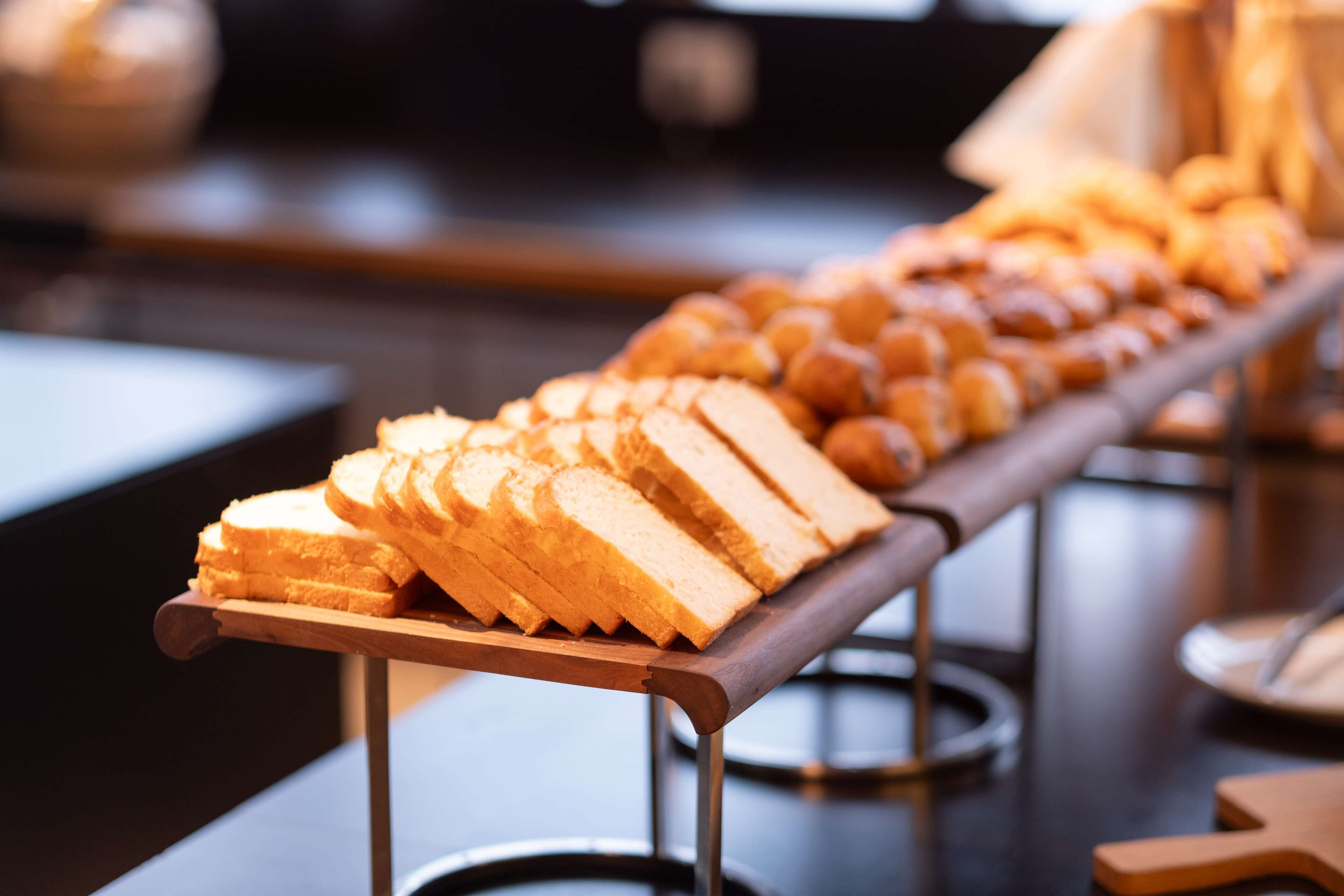 Een buffet met diverse gerechten, waaronder brood en gebak.