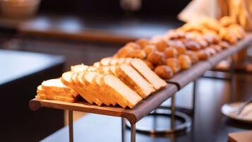 Een buffet met diverse gerechten, waaronder brood en gebak.