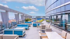 A rooftop terrace with outdoor seating and a view of the city. - Hilton Kinshasa (Kinshasa)
