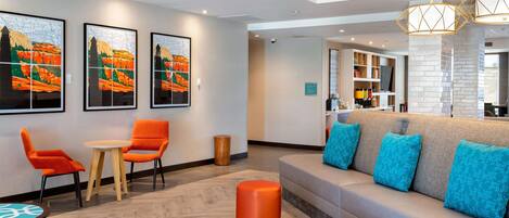 A modern lobby with a sofa, chairs, and artwork on the walls.
