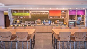 A modern breakfast bar with seating, a coffee machine, and a variety of breakfast items. - Home2 Suites Lake Havasu City, Az (Lake Havasu City)