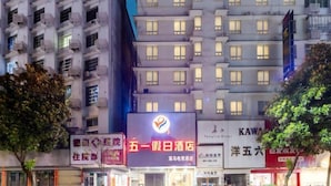 A multi-story building with illuminated signage, including a prominent red sign with white text and a logo. - Wuyi E-Sports Hotel (Chenzhou)