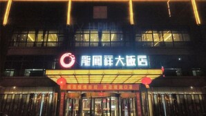 A building with illuminated signage and a glass entrance. - Longfengxiang Hotel (Dongying)