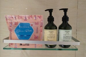 A display shelf with a skincare product package and two bottles of TOUREL. - Longfengxiang Hotel (Dongying)