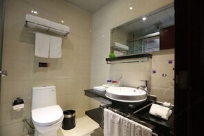 A modern bathroom with a toilet, sink, and mirror. - Longfengxiang Hotel (Dongying)