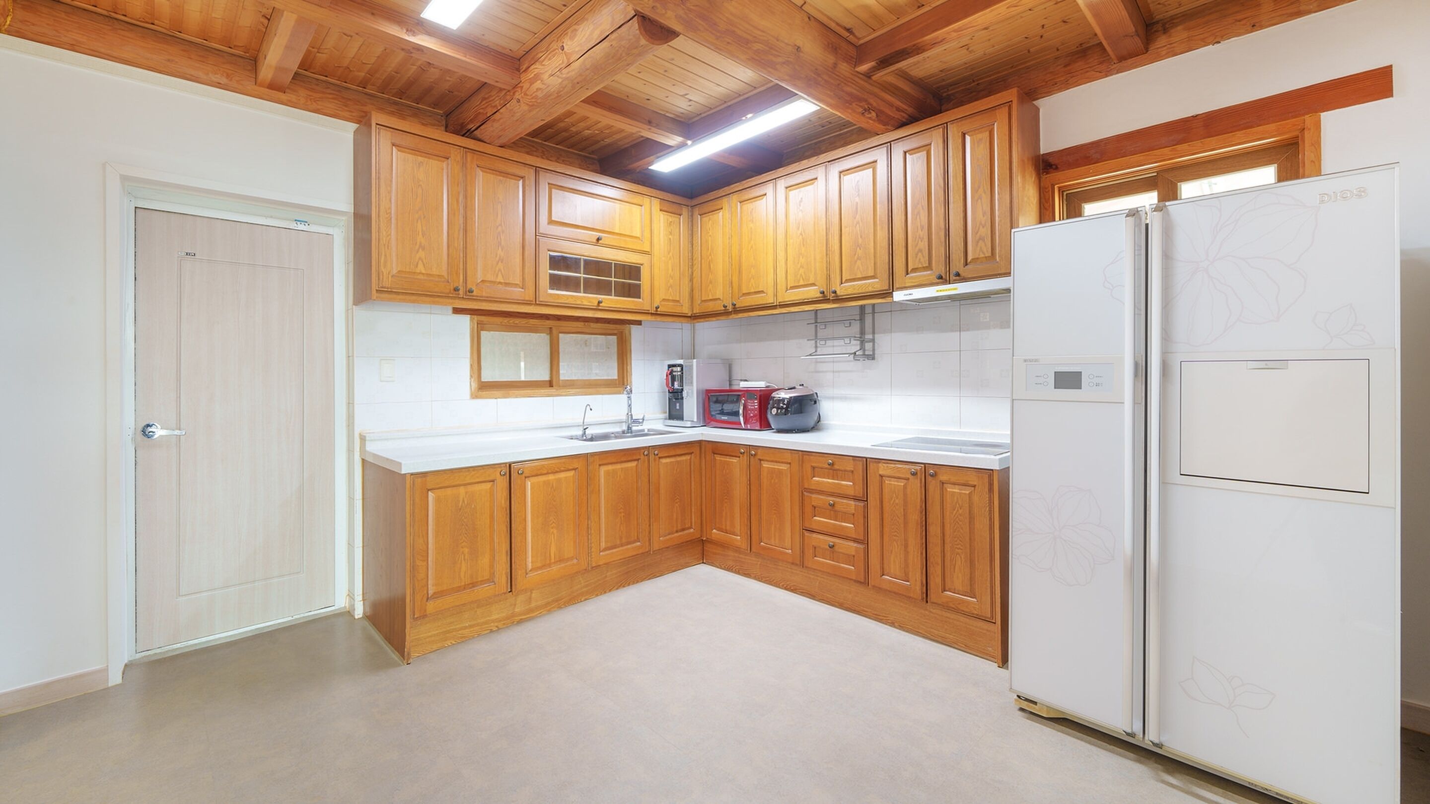 A kitchen with wooden cabinets, a white refrigerator, a microwave, and a toaster.