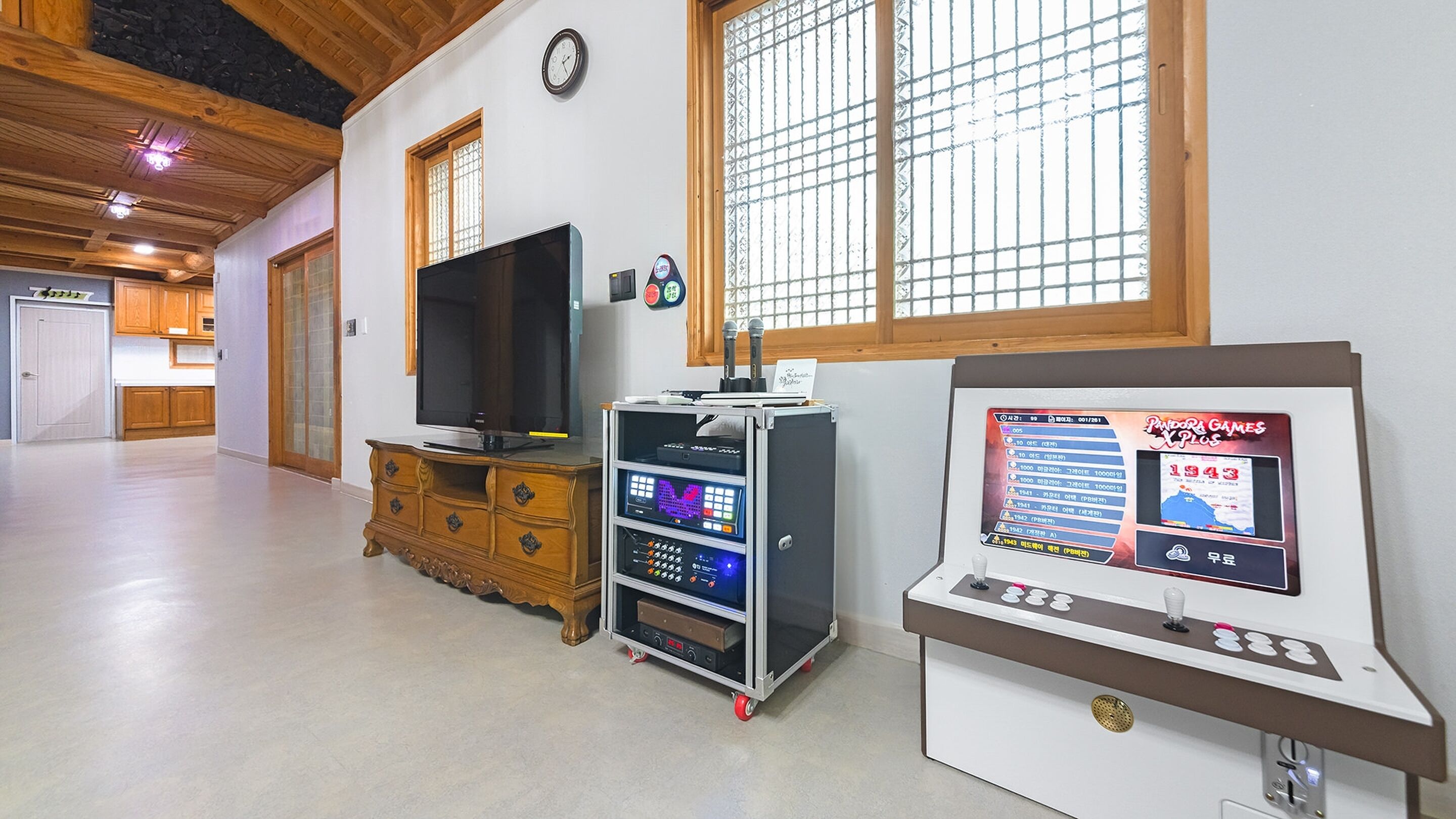 A spacious room with a wooden cabinet, a television, and a digital kiosk displaying historical information.