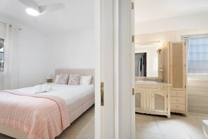 Relax in a spacious bedroom with a large bed, dresser, and vanity.