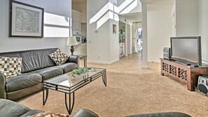 A modern living room with a leather sofa, a glass coffee table, and a TV on a wooden stand. - Sunny, great views, upstairs villa (Cathedral City)