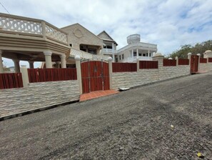 A residential area with houses, a gated entrance, and a paved driveway.