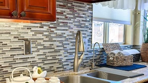 A kitchen with a granite countertop, a stainless steel sink, and a brick backsplash. - Private Vegas Villa with Pool & Spa Perfect for a European Escape (North Las Vegas)