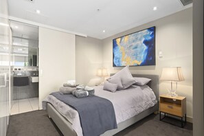 A modern bedroom with a large bed, bedside tables, and a large abstract painting on the wall. - ✔Sophisticated Designer Condo W River & City Views (Southbank)
